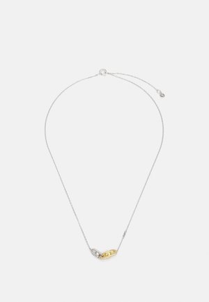 Srebrny naszyjnik łańcuszkowy z akcentem w postaci złotego i przezroczystego kamienia szlachetnego w zakrzywionym wzorze z misternymi detalami.