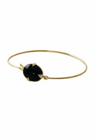 Pulsera de brazalete de oro con una piedra ovalada negra central, acentuada por cuatro gemas claras colocadas en engastes puntiagudos. Acabado suave y pulido.