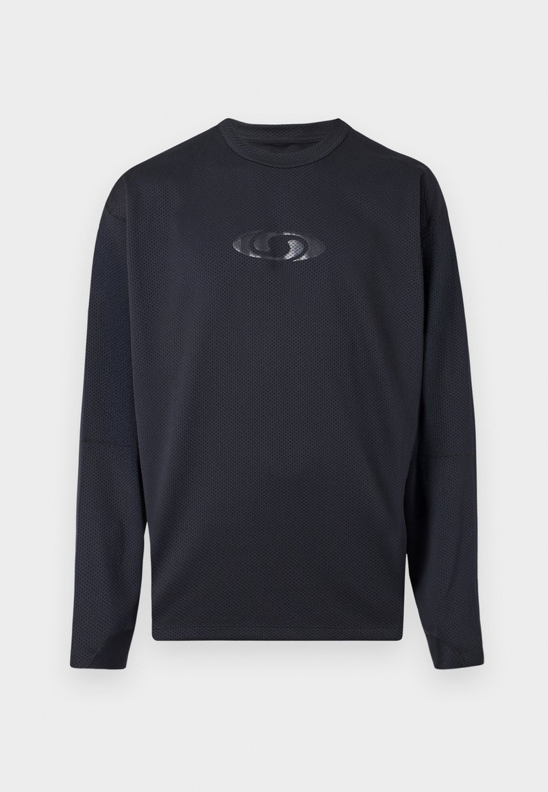 Camisa de manga larga, de un tono azul marino oscuro y texturizado, con un escote redondo y un logo reflectante en el pecho. La tela presenta un patrón de malla que aporta transpirabilidad.