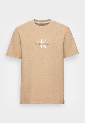 Beige tekstureret T-shirt med korte ærmer, rund halsudskæring og Calvin Klein Jeans logo i hvidt og brunt placeret midt på brystet.