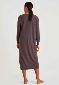Langes, lässig geschnittenes, dunkelgraues Kleid mit langen Ärmeln und rundem Ausschnitt. Seitliche Schlitze sorgen für Bewegungsfreiheit. Weicher, strukturierten Stoff.