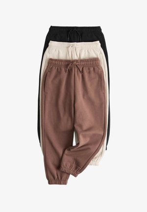 Tre par joggingbukser med elastisk talje i brun, beige og sort, stablet vertikalt mod en hvid baggrund.
