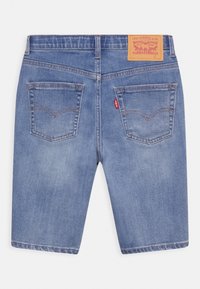 Takakats view mid-bule denim shorts with dua back pockets, stitching details, Levi's red tab, and a tan leather Levi Strauss brand patch.