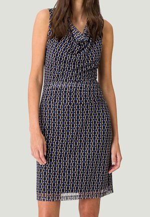 Robe sans manches avec un col drapé, en tissu bleu marine à motif chaînette beige et bleu, silhouette ajustée avec un ourlet droit.