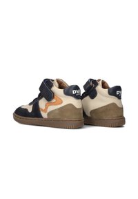 Baskets montantes ajustables avec velcro en daim navy, crème et tan. Présentent des matériaux texturés et des accents de couleur contrastés.