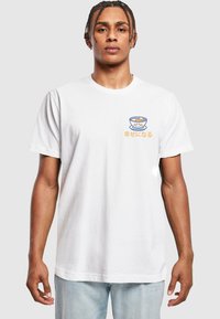 Weißes Baumwoll-T-Shirt mit einem Grafikdruck einer Schüssel mit einem Smiley-Gesicht und Text in Japanisch. Kurze Ärmel und lockere Passform.