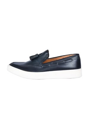 Mocassino slip-on in pelle blu navy con dettaglio a nappa e suola in gomma bianca, visto di lato su sfondo bianco.