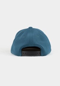 Blaue Fleece-Mütze mit einem geschwungenen Schirm und einem verstellbaren schwarzen Plastikband auf der Rückseite. Verfügt über gestickte Paneele und Belüftungsöffnungen.