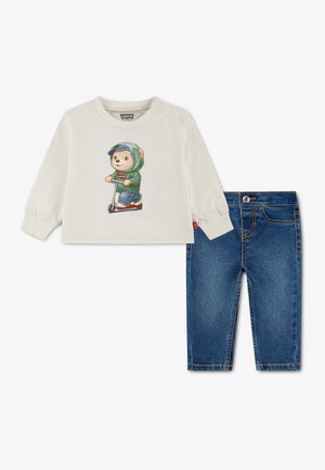 Chemise crème à manches longues avec imprimé ours en trottinette, associée à un jean en denim bleu pour tout-petits.