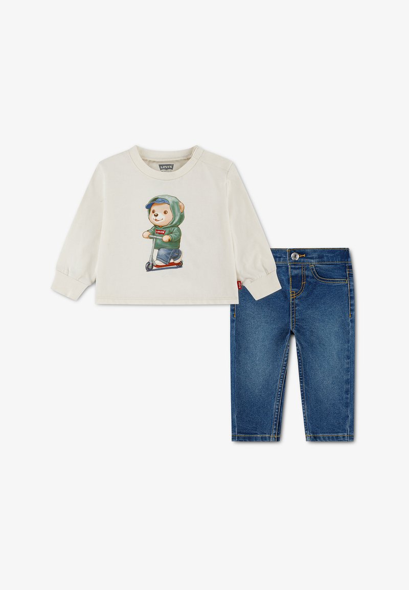 Chemise crème à manches longues avec imprimé ours en trottinette, associée à un jean en denim bleu pour tout-petits.