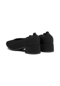 Bailarinas negras de tela suave, diseño de punta redonda, tacones bajos y detalles texturizados en la parte trasera.