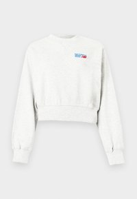 Ανοιχτό γκρι κοντή μπλούζα με μακριά μανίκια και μικρό μπλε και κόκκινο λογότυπο "new balance athletic shoes" στο επάνω μέρος αριστερού στήθους.