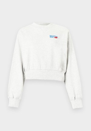 Lichtgrijze cropped sweatshirt met lange mouwen en een klein blauw-rood "new balance athletic shoes" logo op de bovenste linkerborst.