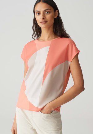 Coral and cream short-sleeve top with abstract shapes and a relaxed fit. Soft fabric with a smooth texture and round neckline.