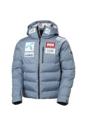 Veste d'hiver matelassée bleu clair avec capuche, fermeture éclair à l'avant, plusieurs logos de sponsors dont Helly Hansen, DNB, KPMG, et badge de l'équipe norvégienne.