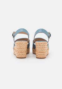 Siniset nahka wedges-sandaalit, joissa on punottu köysi kanta, avoin takakappale ja säädettävä nilkkaremmi. Sileä pinta ja tukeva pohja.