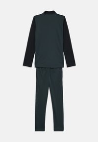 Mörkgrön tvådelad outfit bestående av en långärmad topp med svart krage och svarta ärmar, samt matchande byxor med elastisk midja.