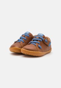 Chaussures en cuir marron avec lacets bleus et une bride velcro. Semelle en caoutchouc flexible avec des coutures tonales et un logo sur la languette. Design à bout rond.