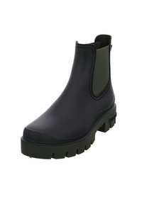 Bota Chelsea de goma negra con panel lateral elástico verde, suela chunky verde y superficie lisa. Presenta una punta redondeada y una cinta de agarre.