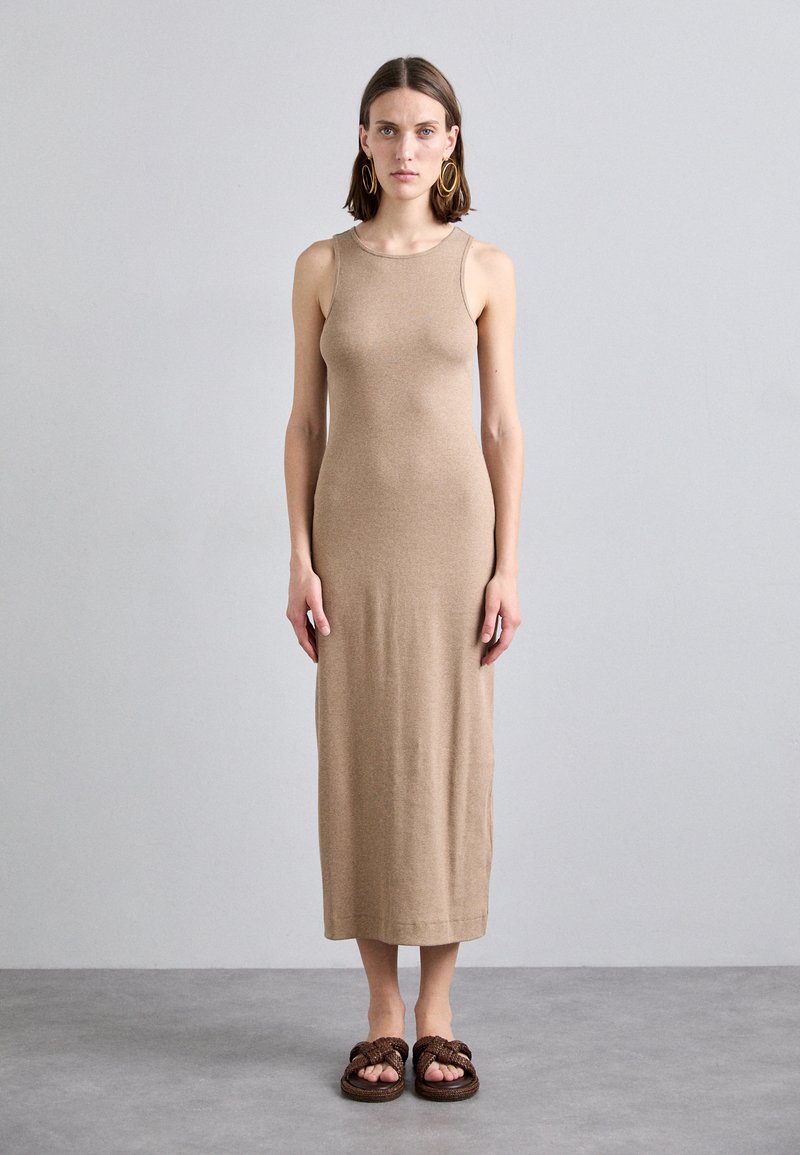 Abito midi in maglia beige con un design aderente senza maniche, caratterizzato da un collo rotondo. Abbinato a sandali slip-on intrecciati marroni.