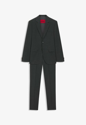 Ciemnoszary dwuczęściowy garnitur męski z marynarką na jeden guzik, z klapami z wycięciem i dopasowanymi spodniami, oznaczony metką HUGO wewnątrz.