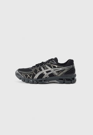 Black running shoe with a textured mesh upper, silver accents, and a cushioned sole featuring segmented rubber for flexibility.