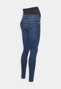 Jeans de maternidad en denimo azul oscuro con una alta cinturilla elástica negra, que cuentan con bolsillos traseros y un diseño de ajuste slim.