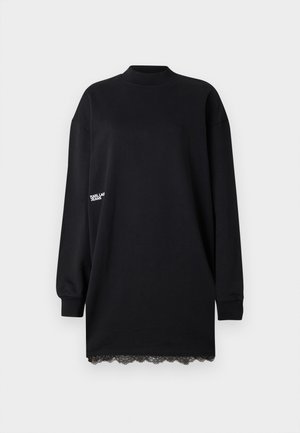 Svart långärmad klänning i bomull. Har en hög halsringning och spetsdetaljer i nederkanten. Minimalistisk design med diskret varumärke på ärmen.