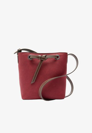 Czerwona zamszowa torebka-bucket z brązowym skórzanym sznurkiem ściągającym oraz regulowanym paskiem na ramię, metalowymi oczkami i białymi detalami przeszycia.