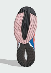 Shoe outsole featuring a multi-patterned tread. Predominantly pink, with black and blue accents, textured for grip and stability.