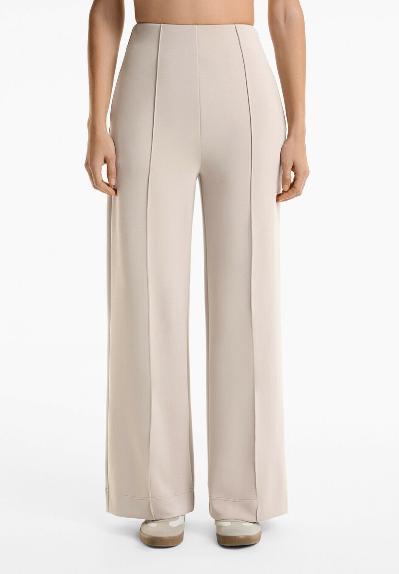 Beige wide-leg trousers with a smooth texture. Features front pleats and a high waistband. Hems are slightly flared. Suited for formal wear.
