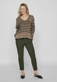 Maglione a righe marroni con scollo a V, vestibilità comoda. Abbinato a pantaloni verdi scuri a sigaretta e scarpe nere slip-on. Design semplice senza motivi visibili.