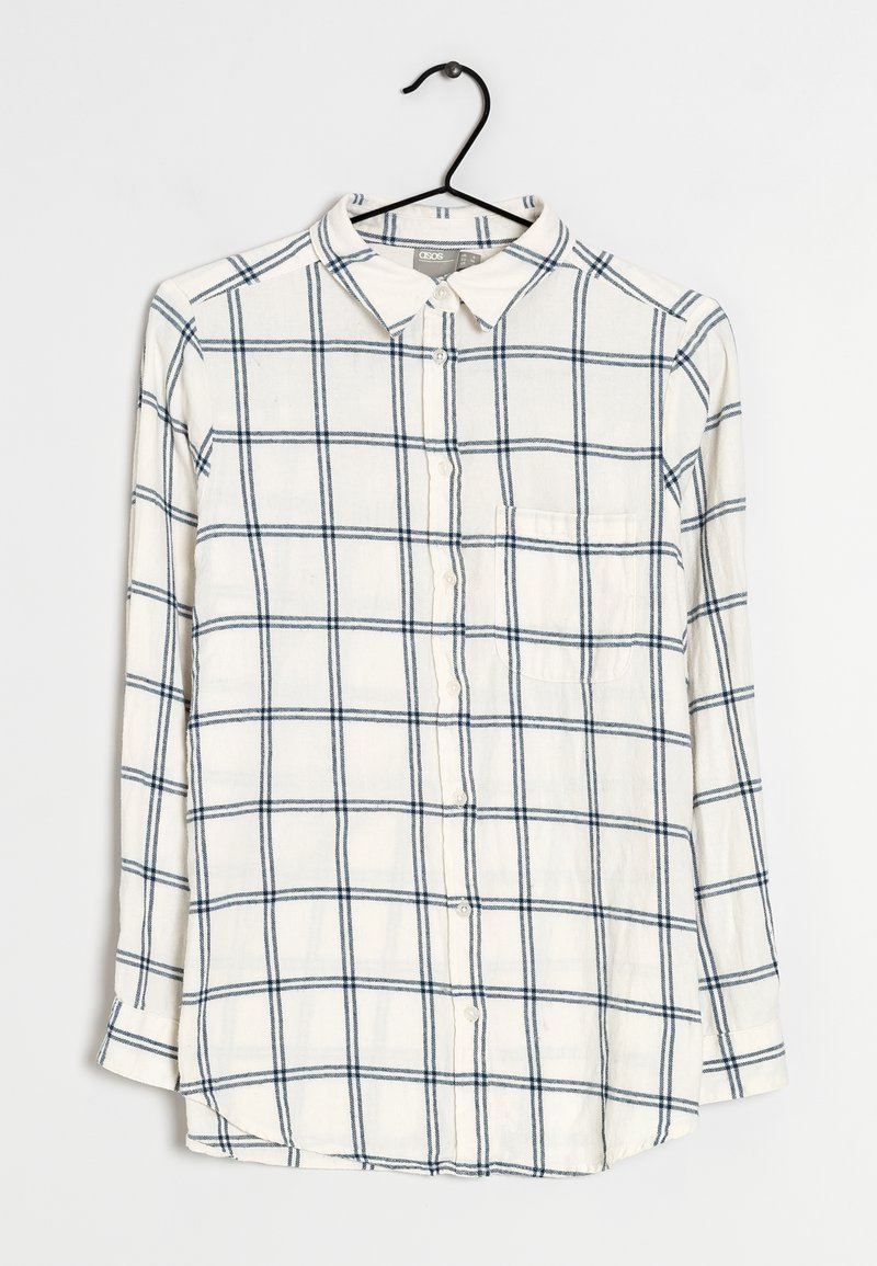 Chemise à manches longues avec boutons, fabriquée en tissu doux, avec une base crème ornée d'un motif à carreaux bleus et une poche sur la poitrine.