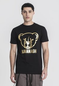 Černé tričko s krátkým rukávem se zlatým grafikou medvěda a textem "KAVANAGH" pod ním, vyrobené z bavlny s hladkou texturou.