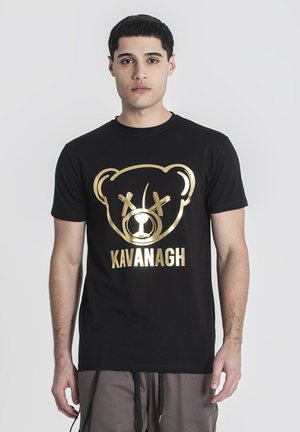 Crna majica kratkih rukava s zlatnim grafikom medvjeda i natpisom "KAVANAGH" ispod, izrađena od pamuka s glatkom teksturom.