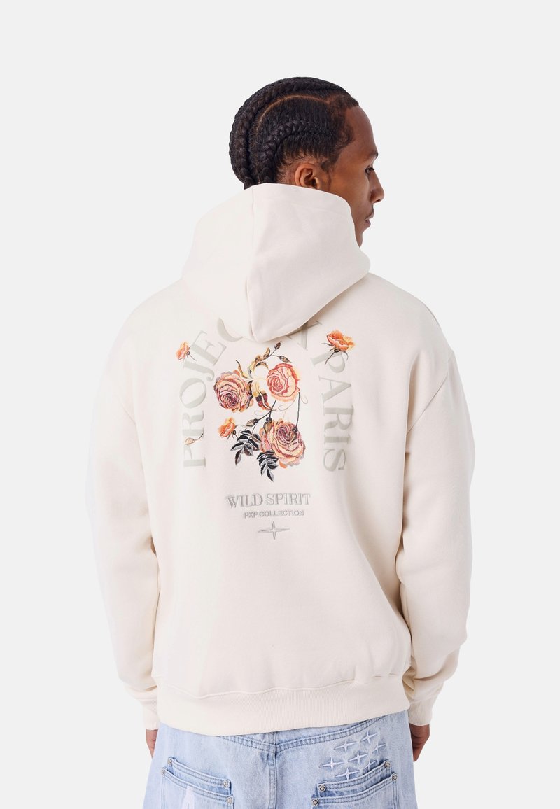 Sudadera con capucha crema que presenta bordados florales en la parte posterior, con el texto "PROJECT PARIS WILD SPIRIT PXP COLLECTION."
