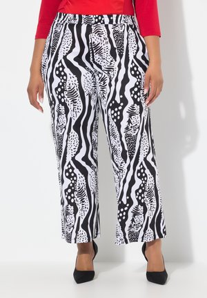 Černobílé patterned široké kalhoty se nepravidelnými pruhy a tečkami; elastický pas, lehká látka. Spárováno s černými podpatky.