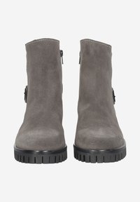 Bottes de cheville en suède gris avec une texture lisse, des zips sur le côté, et des semelles en caoutchouc noir avec des motifs striés pour une meilleure traction.