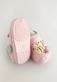 Rosa Clogs mit kuscheliger Innenausstattung, versehen mit dekorativen Applikationen in Form von Bienen und Donuts. Leichtes Material und strukturierte Sohle für besseren Halt. Verstellbarer Riemen.