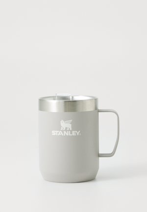 Tasse en métal isolée Gray Stanley avec poignée et couvercle en plastique transparent sur fond blanc.