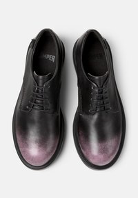 Schwarze Lederschuhe mit glatter Textur, die an der Zehe einen sanften lila Ombre-Effekt aufweisen und ein traditionelles Schnürdesign haben.