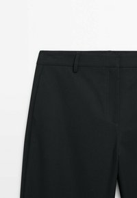 Czarne spodnie o gładkiej fakturze, z prostym krojem, skośnymi kieszeniami i standardowym paskiem.
