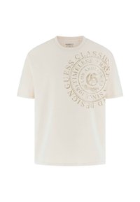 Kremkrāsa kokvilnas T-krekls ar lielu, bēšas krāsas reljefa logotipu apļa dizainā, kurā ir teksts "Guess Classic" un "Los Angeles". Īsās piedurknes.