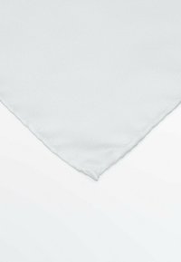 Quadrato di tessuto bianco con una superficie texturizzata e righe diagonali; i bordi sono rifiniti e appaiono lisci con una leggera lucentezza.