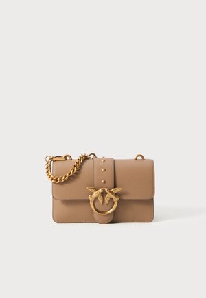 Tan leather handbag featuring a gold chain strap, decorative bird motif on the clasp, stud accents, and a structured rectangular shape.