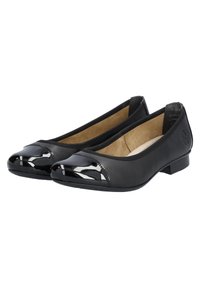 Bailarinas negras con parte superior de cuero mate y punteras de charol brillantes. Tacón bajo y forro interior beige acolchado.