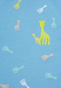 Tessuto azzurro chiaro con un motivo di giraffe multicolori e forchette. Le giraffe sono rappresentate in tonalità gialle e pastello, con dettagli di ricamo.