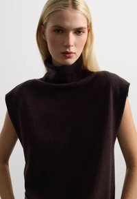 Dunkellila, ärmelloses Turtleneck-Top mit lockerer Passform und weicher Textur. Verfügt über einen hohen, gefalteten Kragen und minimale Nähdetails.