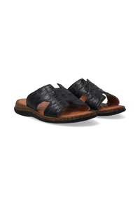 Zwarte slide-sandalen van getextureerd leer met uitsparingen aan de zijkanten en een bruine kurken zool. Voorzien van een gladde binnenvoering en een vlakke voetbed.