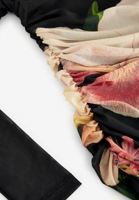 Un material negru se extinde într-o secțiune pliată cu un imprimeu floral în nuanțe de bej, roz și roșu, având o textură transparentă și o suprafață netedă.
